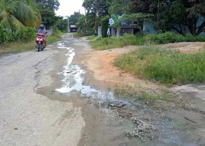 Jalan Rahmat Rusak Parah, Limbah Rumah Tangga Warga Mengalir ke Jalanan